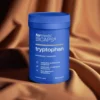 apsułki BiCaps Tryptophan 500 mg - czysty L-Tryptofan w hipoalergicznych kapsułkach celulozowych dla lepszego snu i nastroju, opakowanie na tle brązowej tkaniny