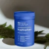 BiCaps Tryptophan - 500 mg czystego L-Tryptofanu w jednej kapsułce bez dodatków i wypełniaczy, opakowanie na tle marmurowej ściany z gałązkami roślin
