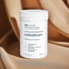 Opakowanie suplementu Colostrum od Formeds - 60 porcji na tle brązowej tkaniny