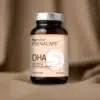 Suplement PRENACAPS DHA dla kobiet w ciąży i karmiących - szklana butelka 60 kapsułek z kwasem DHA 600 mg na naturalnym brązowym tekstylnym tle
