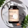PRENACAPS DHA z kwasami omega-3 dla prawidłowego rozwoju mózgu dziecka - elegancka kompozycja na marmurowej tacy z liśćmi oliwnymi symbolizującymi naturalne pochodzenie