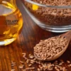 Wysokiej jakości olej lniany z nasionami konopi w tle - naturalny produkt pełen kwasów omega