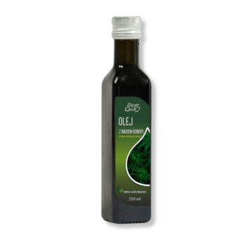 Butelka oleju konopnego Zielony Olej, otoczona roślinami konopi siewnych.