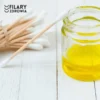 Naturalny olej dla dzieci Zielony Olej w słoiczku, obok pałeczki do uszu