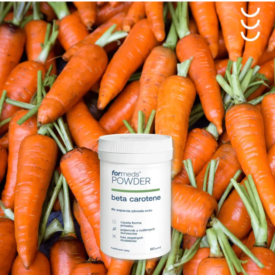 Powder beta-carotene na tle świeżo zerwanych marchewek z zielonymi końcówkami
