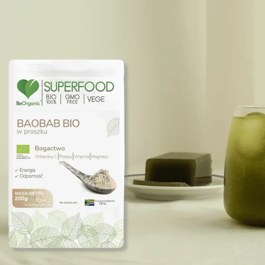 Baobab w proszku stojący w opakowaniu obok szklanki z witaminowym koktailem.