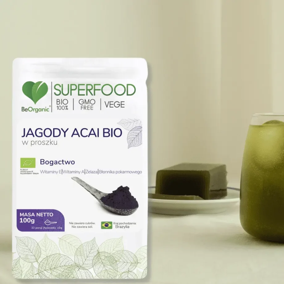 Jagody acai w proszku w opakowaniu stojącym obok szklanki z witaminowym koktailem