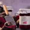 Czerwone buraczki w słoiku, a obok tarka i świeże buraczki