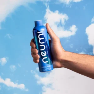Ręka trzymająca suplement nutriswish neumi na tle niebieskiego nieba