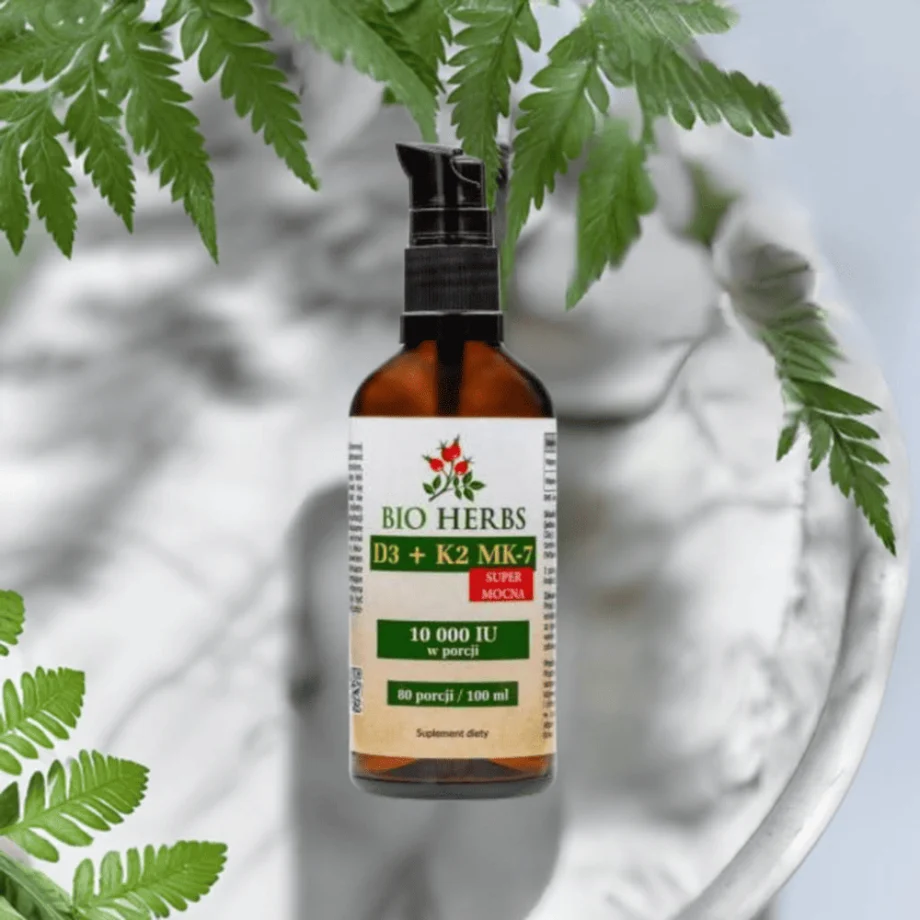 D3 K2 krople 10000 IU Bio-Herbs - płynny suplement na marmurowym blacie z zielonym liściem symbolizującym naturalny skład