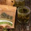 Opakowanie herbaty konopnej wraz z zaparzoną herbatą w szklance na drewnianym stole