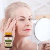 Dojrzała kobieta ze słoiczkiem kolagenu aktywne peptydy od bioherbs.