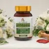 Moja Harmonia Hormonalna - naturalny suplement wspierający równowagę hormonalną u kobiet, opakowanie na białym stole z kwiatami