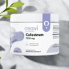 Colostrum w proszku 1200 mg Osavi - naturalne wsparcie odporności i regeneracji w białym opakowaniu na tle marmurowej ściany