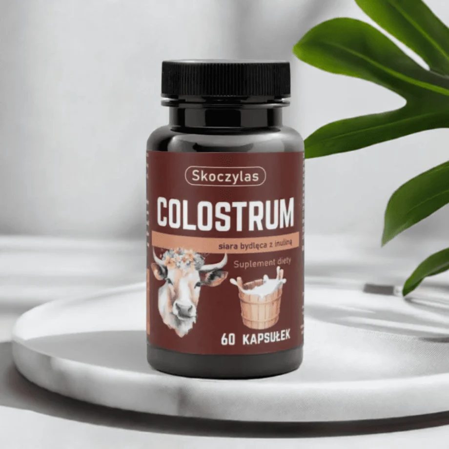 COLOSTRUM Skoczylas - polski suplement łączący wsparcie odporności i mikrobioty jelitowe, opakowanie na marmurowej podstawce
