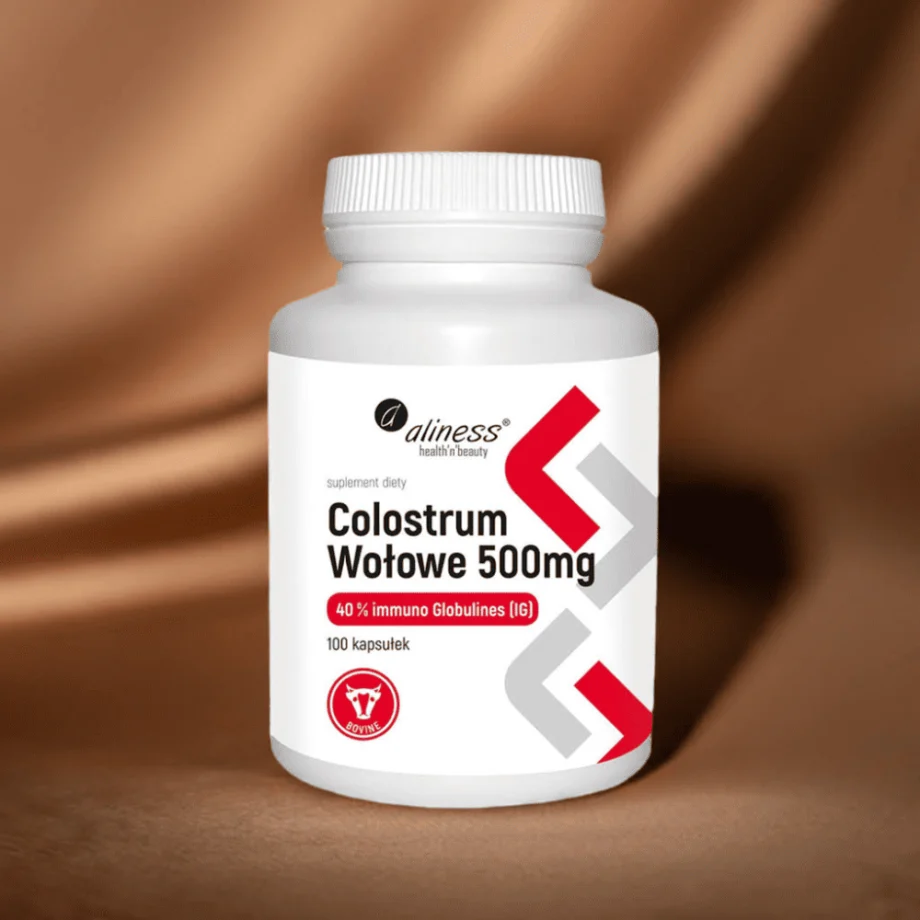 Opakowanie Colostrum Aliness - 100 kapsułek z siarą wołową IG 40%, na tle brązowej tkaniny
