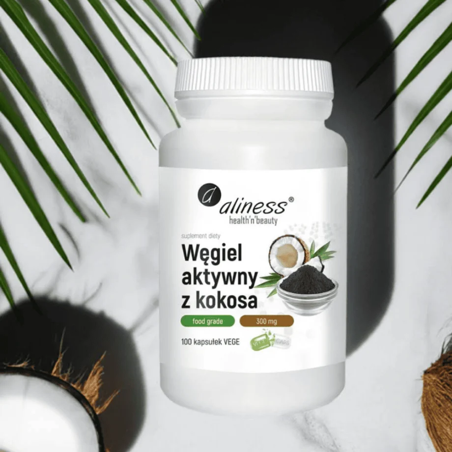 skład węgla aktywnego z kokosa Aliness 300 mg w kapsułkach - 100% naturalny suplement food grade do oczyszczania organizmu w opakowaniu na tle marmurowej ściany