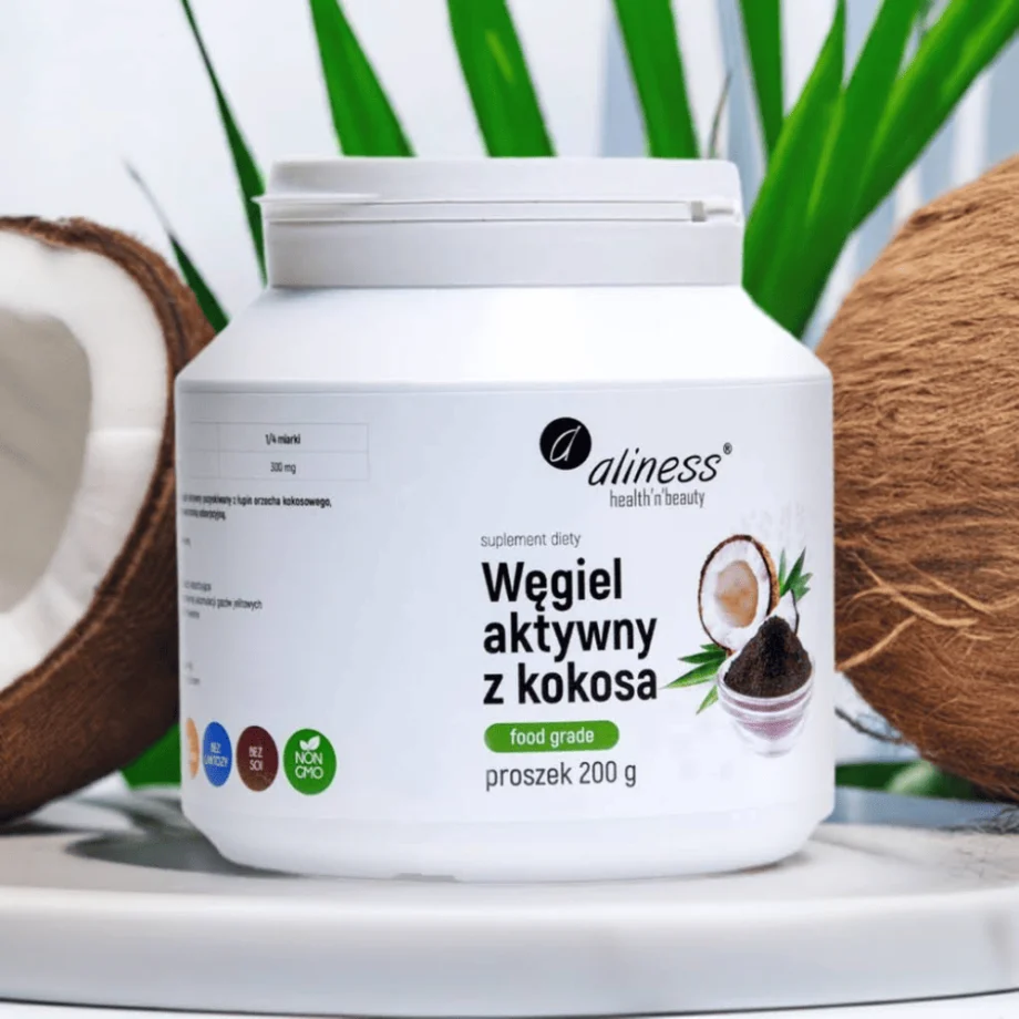 Opakowanie węgiel aktywny z kokosa Aliness w szklance wody - naturalna metoda detoksykacji i wspomagania trawienia w codziennej suplementacji, na tle owocu kokosa