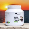 proszek węgla aktywnego z kokosa Aliness 200g - 100% naturalny produkt food grade do oczyszczania organizmu, na tle zachodzącego słońca